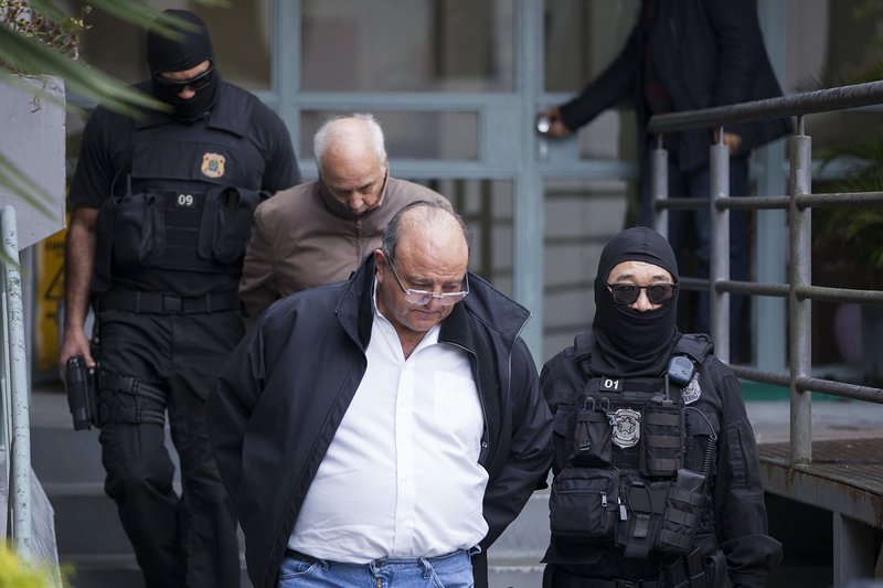 Candido Vaccarezza being arrested and led down steps by police